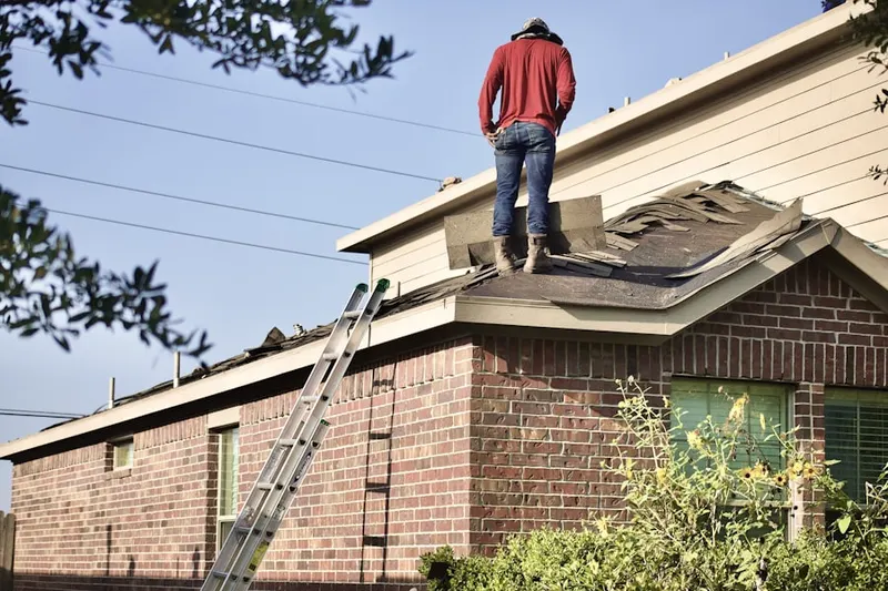 Professional roofer working on a residential roof in Falcons Lair